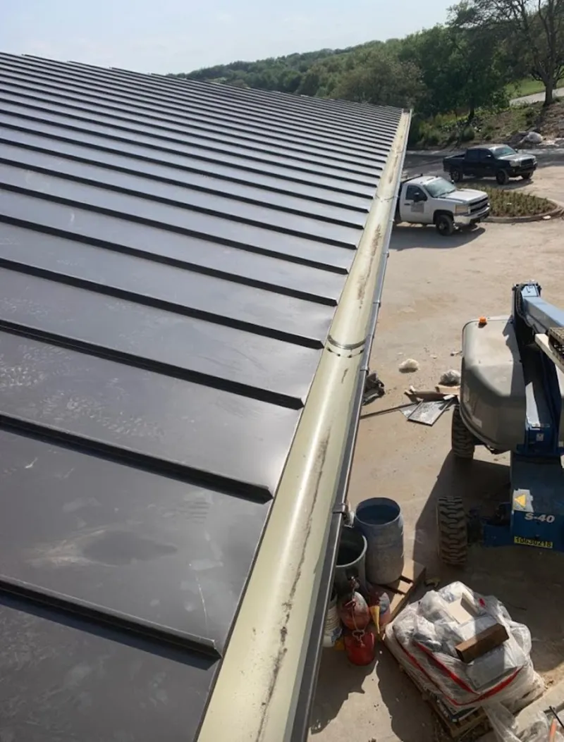 Standing seam panel and gutter detail on a metal roofing jobsite in Mead